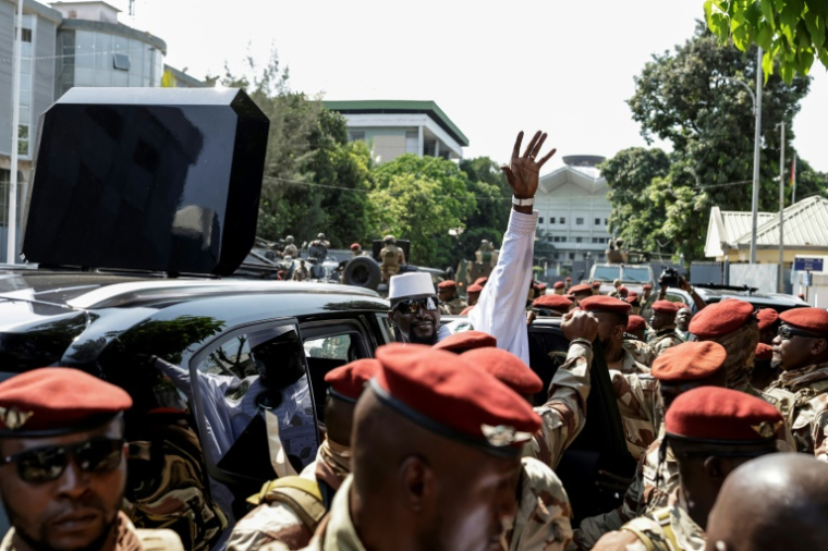 Le président guinéen et candidat à la présidence Mamadi Doumbouya (au centre) salue la foule après avoir voté à Conakry, le 28 décembre 2025, lors de l'élection présidentielle guinéenne. ( AFP / Patrick MEINHARDT )