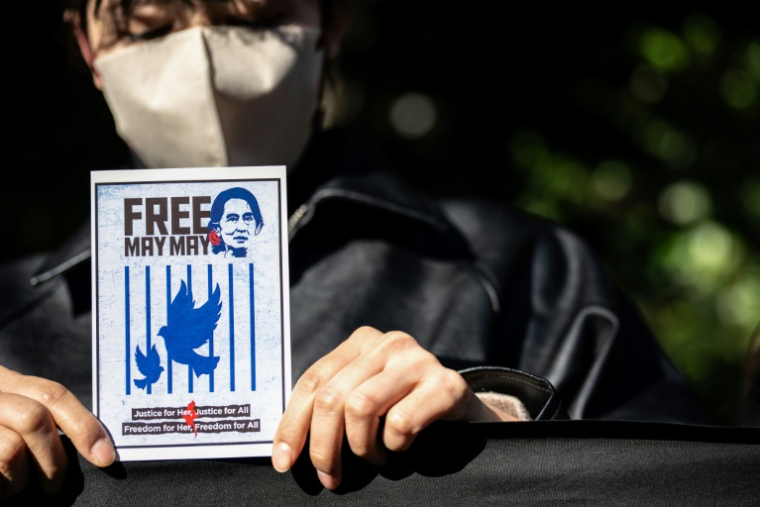 Une femme brandit une pancarte à l'effigie d'Aung San Suu Kyi, dirigeante civile destituée du Myanmar, lors d'un rassemblement de protestation contre les élections générales organisées par le gouvernement militaire birman, devant l'ambassade du Myanmar à Tokyo le 28 décembre ( AFP / Philip FONG )