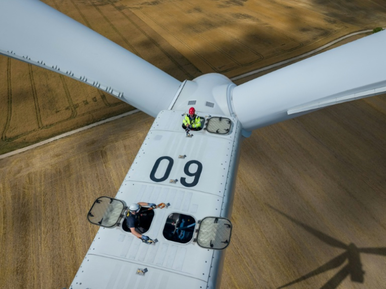 Vue aérienne d'un mineur (en haut) participant à une formation à l'exploitation d'éoliennes avec un instructeur (en bas), au parc éolien de Gorzyca, dans l'ouest de la Pologne, le 8 juillet 2026 ( AFP / Wojtek RADWANSKI )