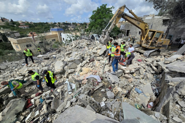 Des secouristes de la protection civile libanaise fouillent les décombres à Deir Qanoun al-Nahr, dans le sud du Liban, le 20 mai 2026, au lendemain des frappes israéliennes ( AFP / KAWNAT HAJU )