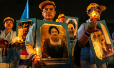 Des partisans de la famille royale tiennent des portraits de la reine mère Sirikit, décédée vendredi, ici le 12 août 2025 à Bangkok ( AFP / Chanakarn Laosarakham )
