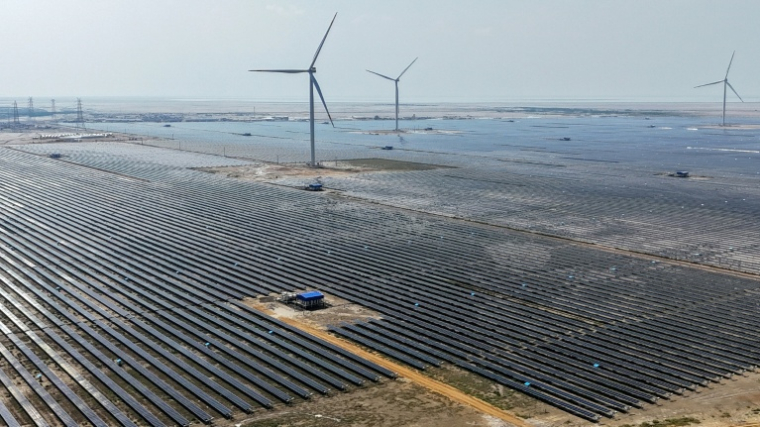 Cette photographie aérienne prise le 15 octobre 2024 montre des éoliennes et des panneaux solaires installés à la centrale d'énergie renouvelable verte d'Adani à Khavda, dans l'État indien du Gujarat ( AFP / Punit PARANJPE )