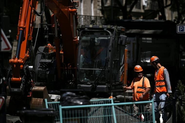 Des ouvriers font une pause sur un chantier de nivellement de chaussée à Bordeaux, le 6 juillet 2026 en Gironde, lors d'une nouvelle vague de chaleur en France ( AFP / Christophe ARCHAMBAULT )