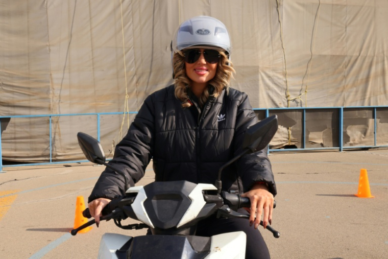 Mona apprend à conduire une moto dans un centre d'entraînement du nord de Téhéran, le 7 décembre 2025 en Iran ( AFP / ATTA KENARE )