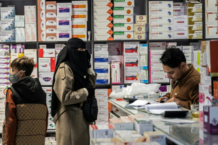 Une femme achète des médicaments dans une pharmacie à Kaboul, le 9 février 2026 en Afghanistan ( AFP / Wakil KOHSAR )