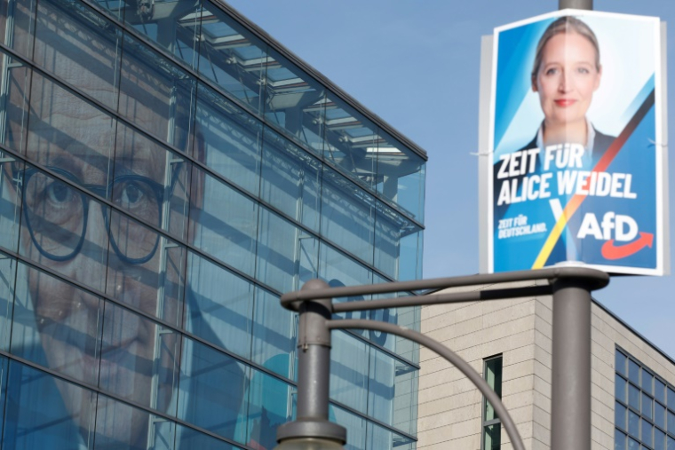 Affiche électorale d'Alice Weidel, cheffe de fil du parti allemand d'extrême droite AfD, (D) devant le QG du parti chrétien-démocrate CDU de Friedrich Merz (G), le 24 février 2025 à Berlin ( AFP / Odd ANDERSEN )