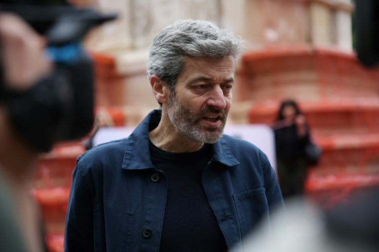 Jean-François Julliard, directeur général de Greenpeace France, s'adresse aux médias devant la Fontaine des Innocents colorée en rouge, lors d'une manifestation de soutien au peuple palestinien, le 28 mai 2025 à Paris ( AFP / Leo VIGNAL )