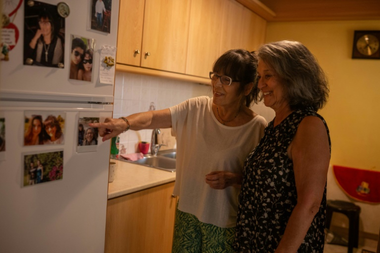 Joanna Robyn Bedell Zalewa (d) et sa soeur Sophie regarde des photos de famille dans leur maison à Elefsina, près d'Athènes, le 5 juin 2025 en Grèce ( AFP / Angelos TZORTZINIS )