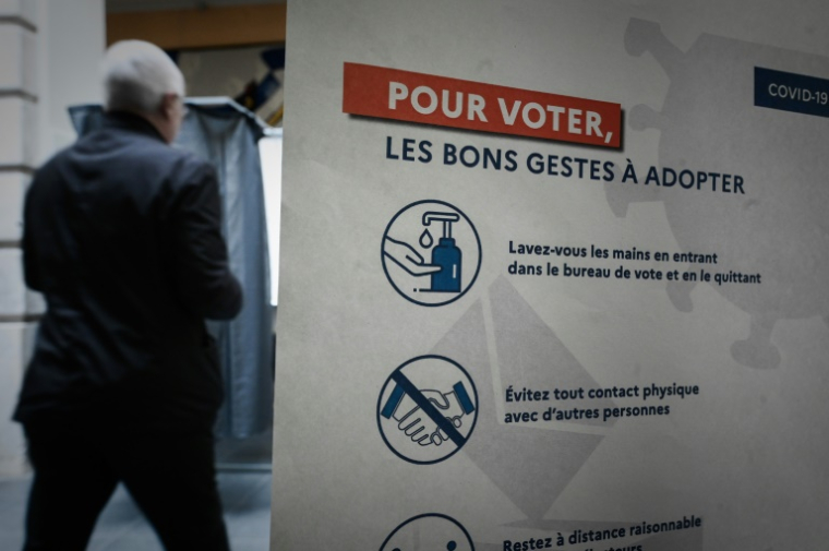 Un panneau indique les consignes à respecter lors du premier tour des élections municipales, le 15 mars 2020 à Paris ( AFP / Philippe LOPEZ )