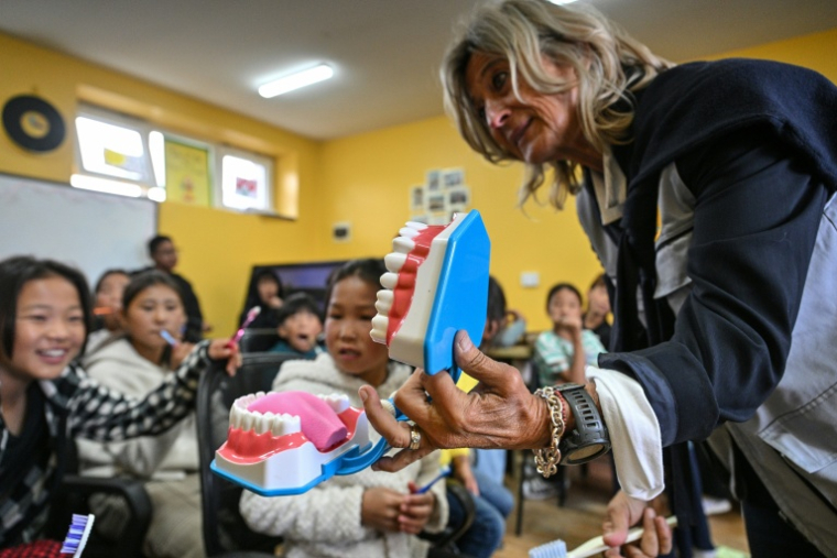 L'hygiéniste dentaire suisse et fondatrice de la Misheel Kids Foundation  Gabriella Schmidt-Corsitto apprend à des enfants l'hygième bucco-dentaire dans une clinique mobile à Oulan-Bator, le 28 août 2026 ( AFP / Hector RETAMAL )