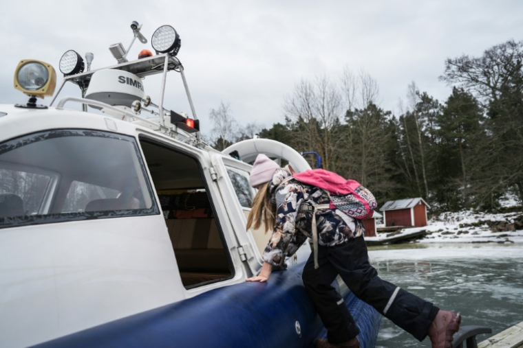 Une écolière embarque à bord d'un aéroglisseur pour rentrer de l'école, le 3 mars 2026 à Paragas, en Finlande ( AFP / Alessandro RAMPAZZO )