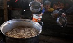Des enfants palestiniens attendent de recevoir de la nourriture préparée par une cuisine caritative dans un contexte de pénurie alimentaire, à Rafah