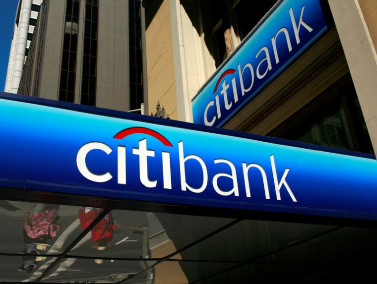 Des personnes marchent sous le logo d'une succursale de la Citibank dans le quartier financier de San Francisco, en Californie