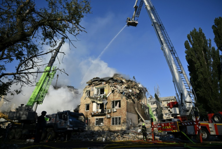 Des sauveteurs ukrainiens sur le site d'un immeuble résidentiel gravement endommagé lors d'une attaque massive de drones et de missiles russes sur Kiev, le 28 août 2025 ( AFP / Genya SAVILOV )