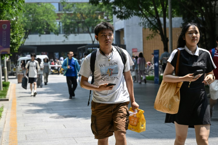 Un étudiant chinois devant l'Université des études internationales de Pékin, portant un t-shirt sur le marathon de New York, le 29 mai 2025 ( AFP / Jade GAO )