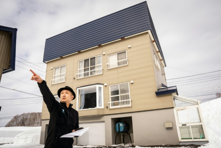 L'agent immobilier Hiroshi Hasegawa présente la vue depuis un bien situé à Niseko, dans la préfecture d' Hokkaido, au Japon, le 20 février 2026 ( AFP / Yuichi YAMAZAKI )