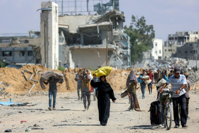 Des Palestiniens marchent sur une route dans le centre de Khan Younès, dans le sud de la bande de Gaza, le 10 octobre 2025 ( AFP / Omar AL-QATTAA )