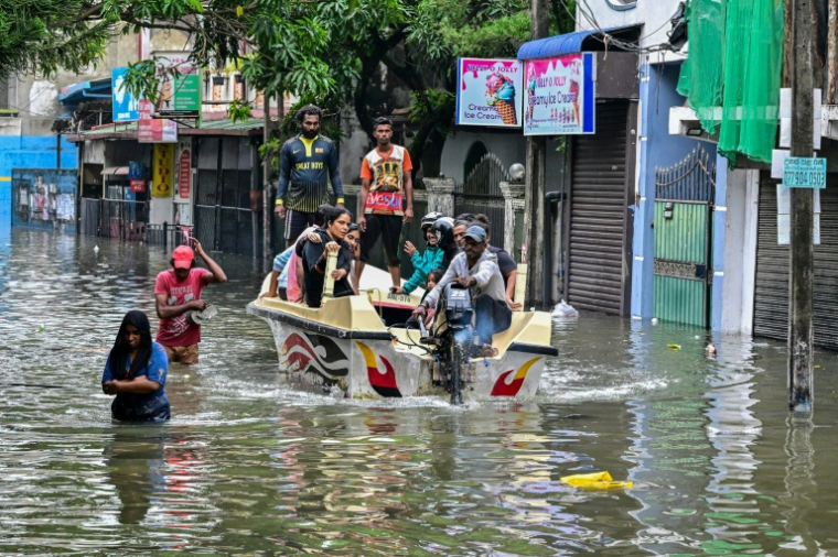 Des habitants évacués en bateau après de fortes pluies à Wellampitiya, en périphérie de Colombo, le 29 novembre 2025 au Sri Lanka ( AFP / Ishara S. KODIKARA )