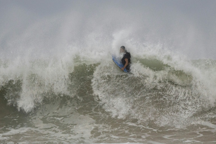 A Luquillo, ville côtière de Porto Rico (Etats-Unis), des surfeurs profitent des vagues à l'approche de l'ouragan Erin le 16 août 2025 ( AFP / Ricardo ARDUENGO )