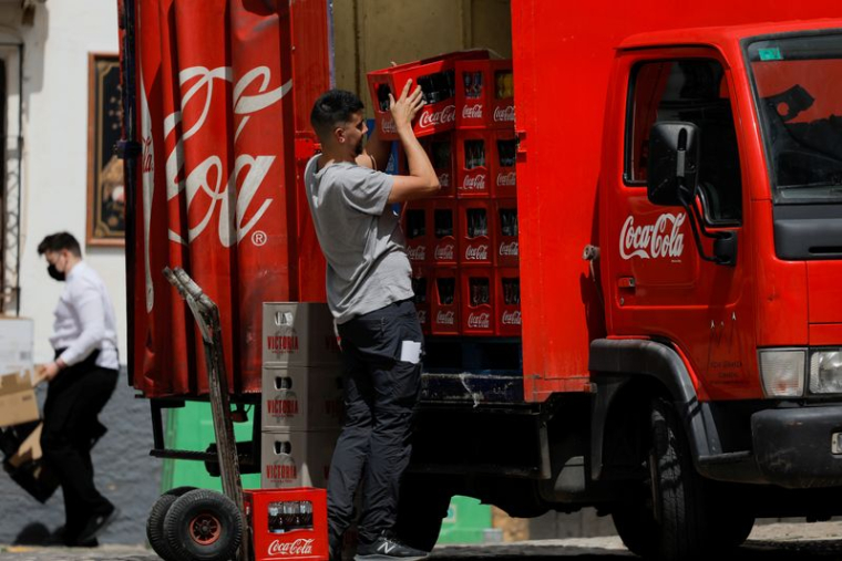Un livreur décharge des caisses de bouteilles Coca-Cola d'un camion à Ronda, en Espagne