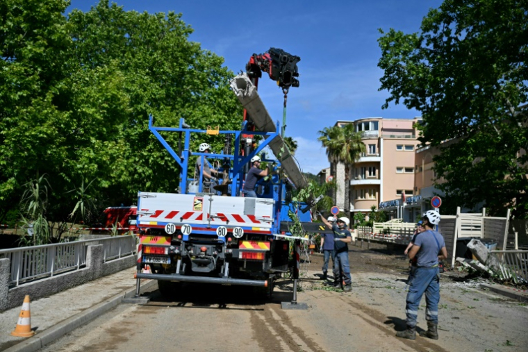 Une grue soulève un poteau électrique cassé après une inondation causée par de fortes pluies dans le village de Cavalière, commune du Lavandou dans le département du Var, dans le sud-est de la France, le 20 mai 2025 ( AFP / Christophe Simon )
