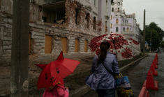 Une mère et sa fille passent près d'un bâtiment détruit par un bombardement russe, le 12 juin 2025 à Soumy, dans le nord-est de l'Ukraine  ( AFP / Florent VERGNES )