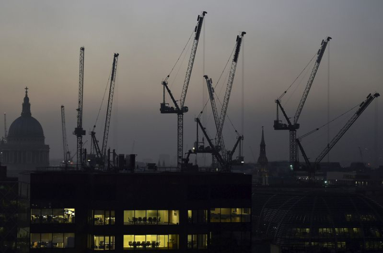 Des bureaux au crépuscule devant la cathédrale Saint-Paul et des grues de construction à Londres