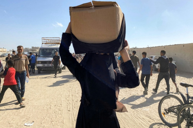 Une femme emporte un carton d'aide distribué par la Fondation humanitaire de Gaza, à Rafah, dans le sud de la bande de Gaza, le 27 mai 2025 ( AFP / - )