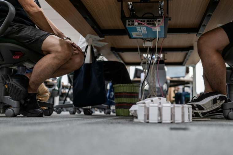 Des fonctionnaires en shorts, t-shirt et baskets, dans les bureaux du siège du gouvernement métropolitain de Tokyo,dans le cadre de l'initiative "Cool Biz" le 14 juillet 2026 lors d'une vague de fortes chaleurs ( AFP / Philip FONG )