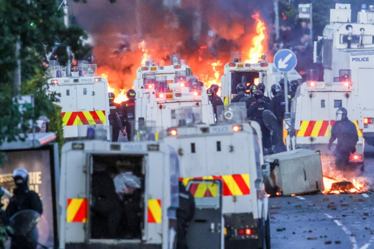 Des incendies à proximité des forces de l'ordre, lors des manifestations à Glengormley, quartier au nord de Belfast (Irlande du Nord), le 10 juin 2026 ( AFP / Paul Faith )