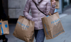 Une femme porte des sacs de shopping Primark sur Oxford Street, à Londres