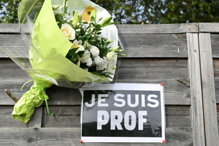 Des fleurs et une affiche "Je suis prof" près du collège du Bois d'Aulne à Conflans-Sainte-Honorine, dans les Yvelines, le 16 octobre 2023 ( POOL / Bertrand GUAY )