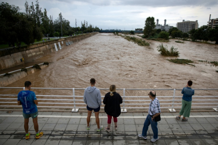 Des habitants regardent le fleuve Besòs, gonflé par des pluies torrentielles, le 4 octobre 2026 à Sant Adrià de Besòs, en périphérie de Barcelone  ( AFP / Josep LAGO )