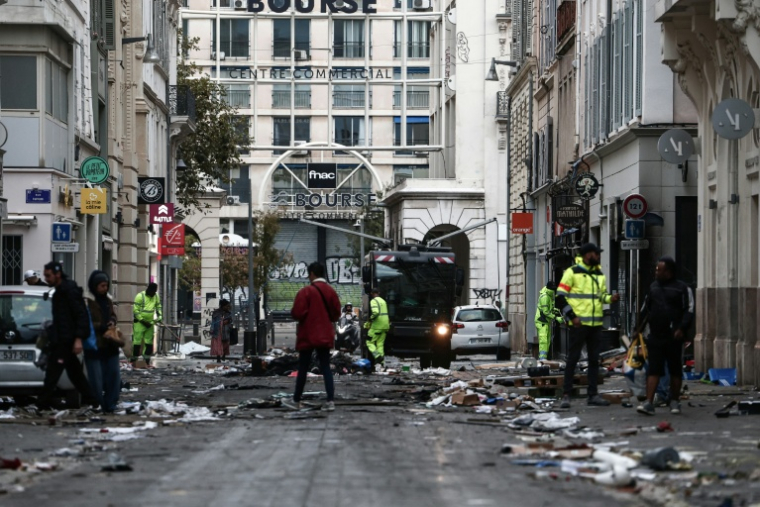 Des employés municipaux nettoient une rue jonchée de débris au lendemain d'une manifestation contre la vie chère, le 18 octobre 2026 à Marseille ( AFP / Thibaud MORITZ )