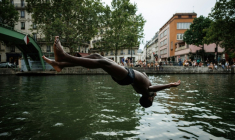 Un jeune saute dans le Canal Saint-Martin à Paris le 3 août 2026 ( AFP / Simon WOHLFAHRT )