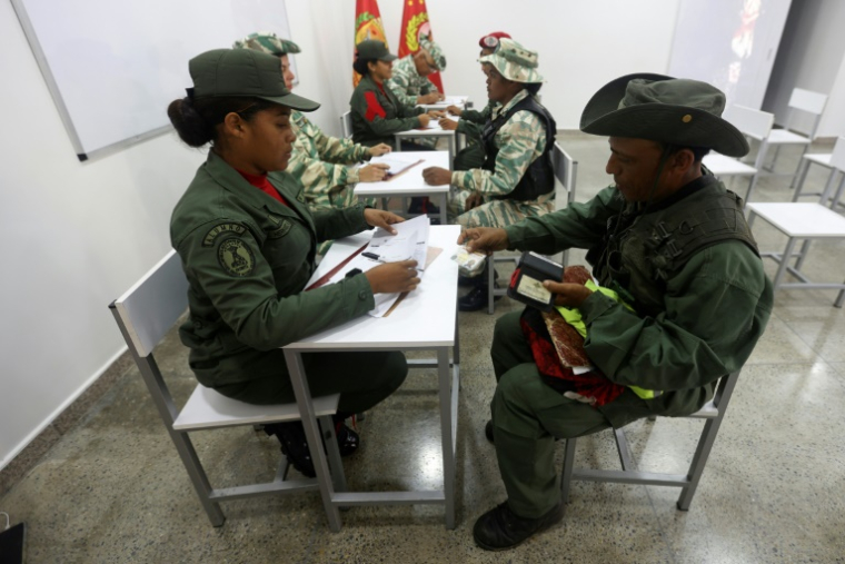 Des personnes s'inscrivent pour rejoindre les forces militaires lors d'une campagne nationale d'enrôlement lancée par le président Nicolas Maduro, le 23 août 2025 à Caracas ( AFP / Pedro MATTEY )
