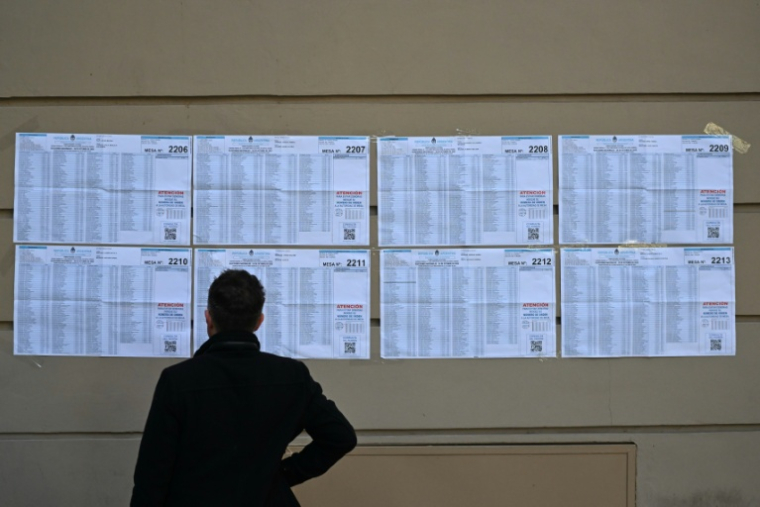 Un homme devant des listes électorales lors des législatives de mi-mandat en Argentine, le 26 octobre 2025 à Buenos Aires ( AFP / Luis ROBAYO )