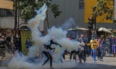 Un manifestant renvoie une grenade lacrymogène vers les forces de l'ordre lors d'une grève nationale organisée pour protester contre les hausses d'impôts et le projet de loi de finances 2024, dans le centre-ville de Nairobi, le 25 juin 2024 ( AFP / Tony KARUMBA )