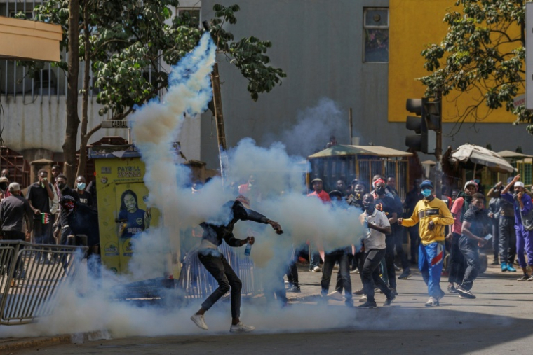 Un manifestant renvoie une grenade lacrymogène vers les forces de l'ordre lors d'une grève nationale organisée pour protester contre les hausses d'impôts et le projet de loi de finances 2024, dans le centre-ville de Nairobi, le 25 juin 2024 ( AFP / Tony KARUMBA )
