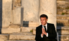 Le président français Emmanuel Macron salue le public à son arrivée sur scène lors d'un événement à l'Agora romaine d'Athènes, le 24 avril 2026 en Grèce ( AFP / Aris MESSINIS )