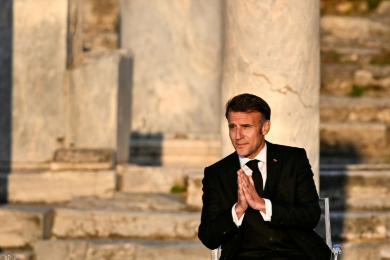 Le président français Emmanuel Macron salue le public à son arrivée sur scène lors d'un événement à l'Agora romaine d'Athènes, le 24 avril 2026 en Grèce ( AFP / Aris MESSINIS )