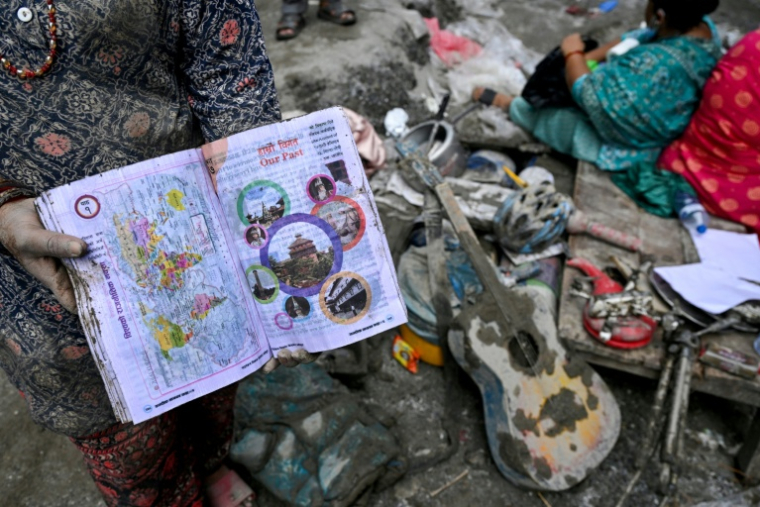 Des habitants récupèrent des objets après les crues à Devighat dans le district de Nuwakot, au Népal, le 31 août 2026 ( AFP / Arun SANKAR )