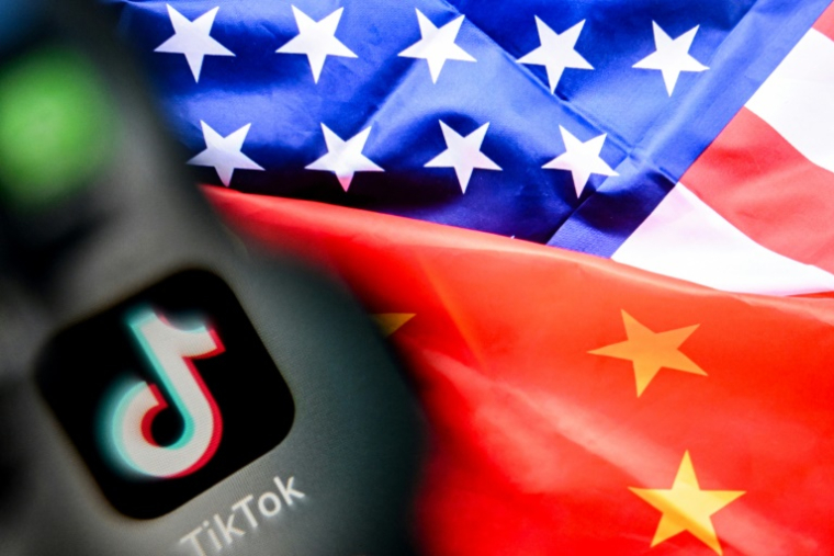 Logo du réseau social TikTok avec les drapeaux de la Chine et des Etats-Unis, le 10 avril 2025 ( AFP / Kirill KUDRYAVTSEV )