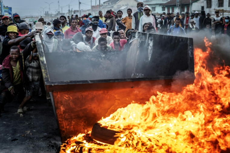Des manifestants poussent un bac à ordures pour ériger une barricade, le 9 octobre 2025 à Antananarivo (Madagascar) ( AFP / Luis TATO )