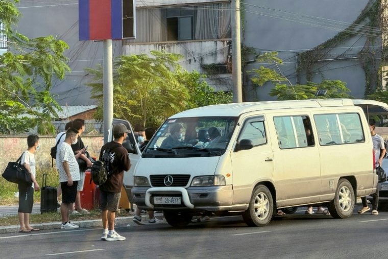Des personnes s'apprêtent à monter dans un véhicule après avoir quitté un complexe suspecté d'être un centre d'escroquerie à Sihanoukville, le 15 janvier 2026 au Cambodge ( AFP / TANG CHHIN Sothy )