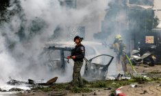 Un pompier israélien éteint l'incendie sur un véhicule suite à l'impact d'un projectile lancé lors d'une frappe iranienne dans le sud de Tel-Aviv, le 15 mars 2026 ( AFP / Jack GUEZ )