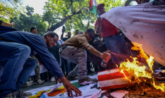 Des manifestants brûlent le drapeau des États-Unis et celui d’Israël lors d’une protestation à Caracas le 24 juillet 2026 ( AFP / Maxwell BRICENO )