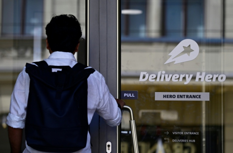 Un employé arrive au siège de l'entreprise allemande de livraison de repas Delivery Hero, le 16 juillet 2026 à Berlin ( AFP / John MACDOUGALL )