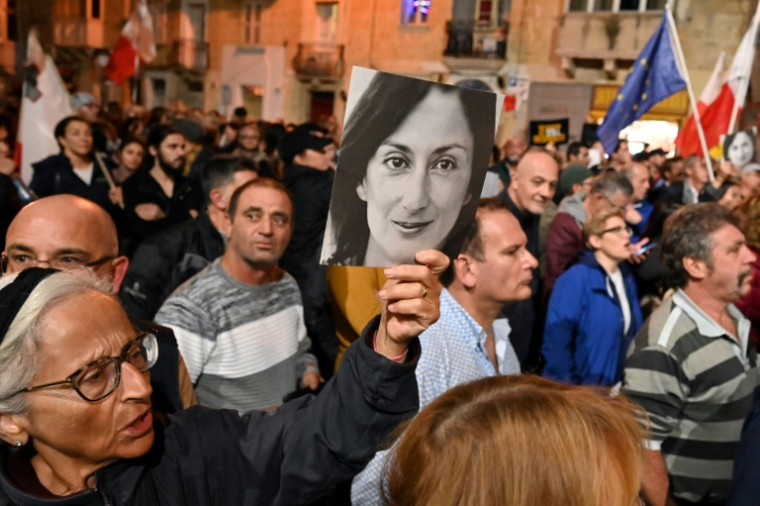 People hold placards and photos of killed journalist Daphne Caruana Galizia during a protest called for by Galizia's family and civic movements on December 3, 2019 outside the police headquarters in Valletta. The scandal-dogged probe into the murder of investigative reporter Daphne Caruana Galizia has damaged relations between Malta and the EU, the head of a European Parliament fact-finding delegation said on December 3. The urgent mission of seven MEPs to the Mediterranean island follows an escalation in the murder case and Prime Minister Joseph Muscat's decision to resign over what critics have called a botched investigation. ( AFP / ANDREAS SOLARO )