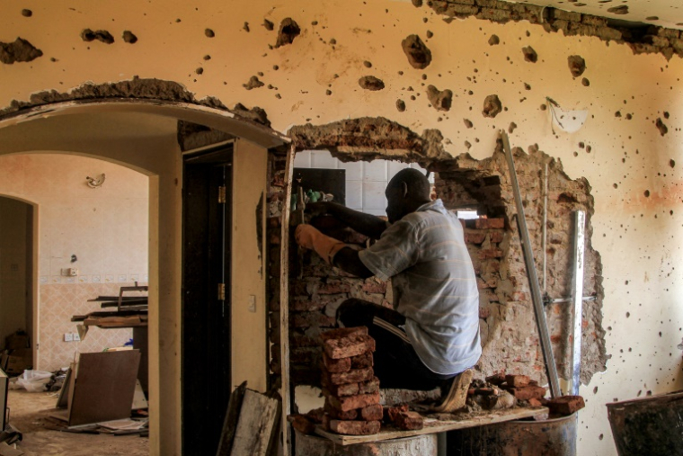 Un ouvrier du bâtiment travaille dans un appartement endommagé d'un un immeuble de la banlieue de Lambab, à la périphérie de Khartoum, le 30 juillet 2025 au Soudan ( AFP / Ebrahim HAMID )